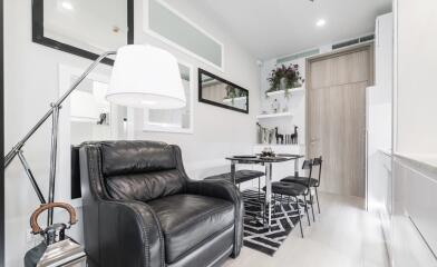 Modern living room with a black leather chair and dining area