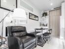 Modern living room with a black leather chair and dining area