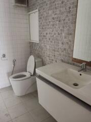 Modern bathroom with tiled walls and white fixtures