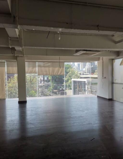 Spacious empty room with large windows and city view