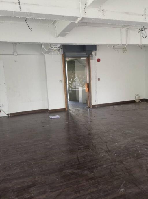 Empty room with dark floor and partially painted walls