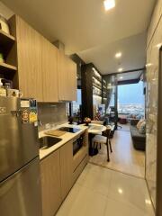 Compact modern kitchen leading to an open living area with city views