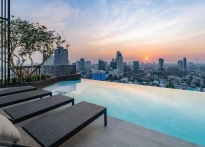 Rooftop infinity pool with city skyline view at sunset