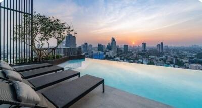 Rooftop infinity pool with city skyline view at sunset