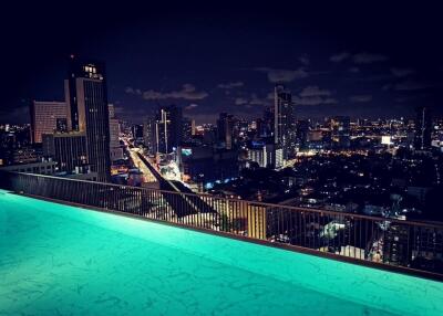 Night view of city skyline from rooftop swimming pool