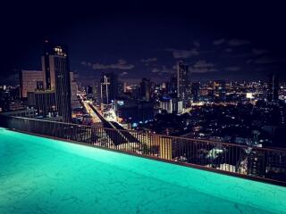 Night view of city skyline from rooftop swimming pool