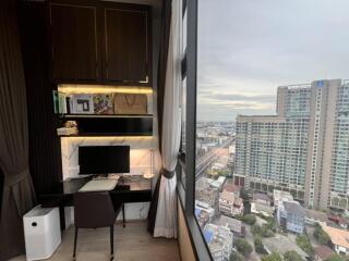 Modern bedroom with work desk and large window overlooking cityscape