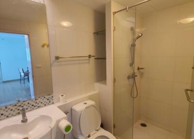 Modern bathroom with glass-enclosed shower and white fixtures