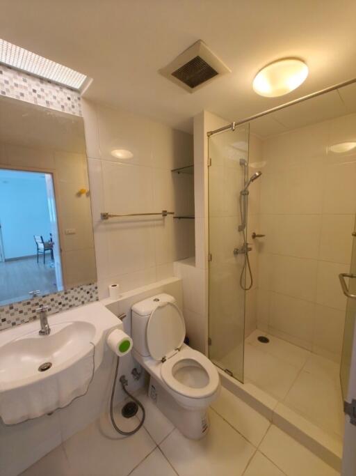 Modern bathroom with glass-enclosed shower and white fixtures