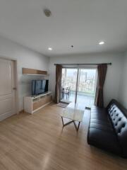 Spacious living room with balcony access and city view