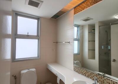 Modern clean bathroom with toilet, sink, shower, and large mirror