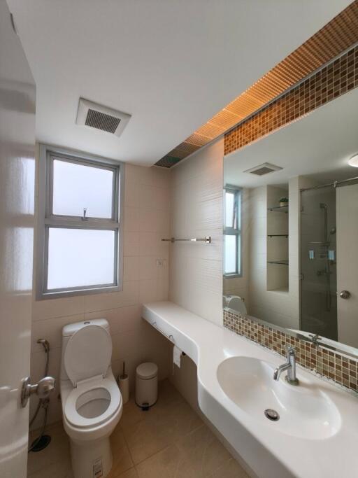 Modern clean bathroom with toilet, sink, shower, and large mirror