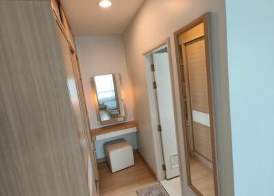 Walk-in closet area with vanity and full-length mirror