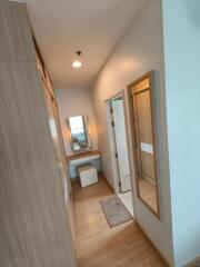 Walk-in closet area with vanity and full-length mirror