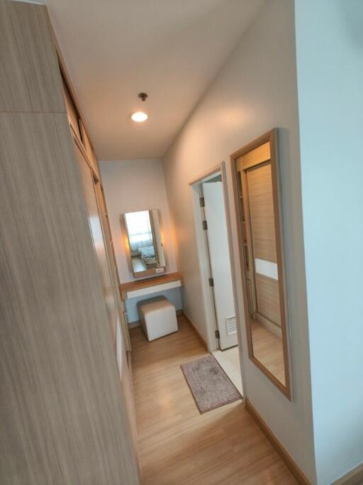 Walk-in closet area with vanity and full-length mirror