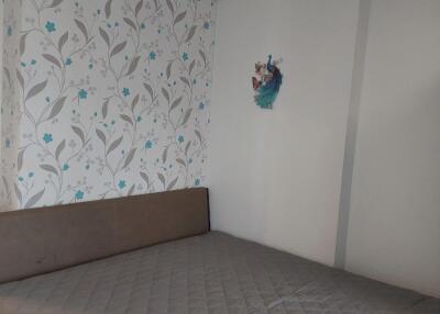 Bed with floral wallpaper