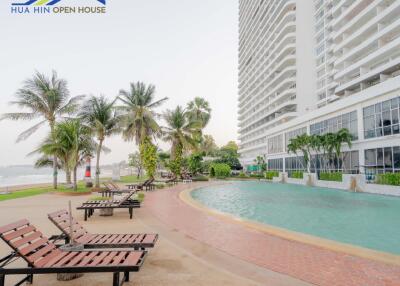 Outdoor pool area with lounge chairs by high-rise building