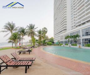 Outdoor pool area with lounge chairs by high-rise building