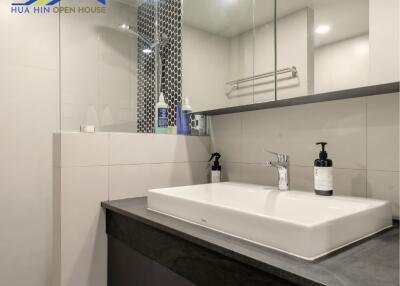 Modern bathroom with a rectangular sink, large mirror, and stylish decor