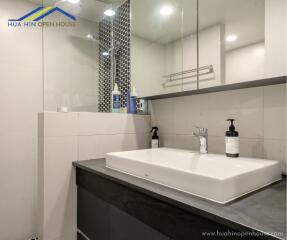 Modern bathroom with a rectangular sink, large mirror, and stylish decor