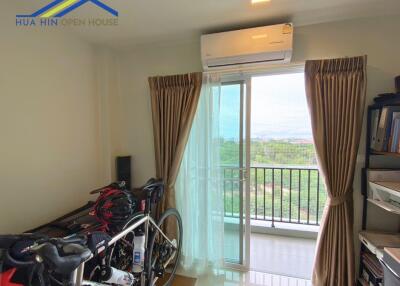 Bedroom with large window, air conditioner, and exercise bikes