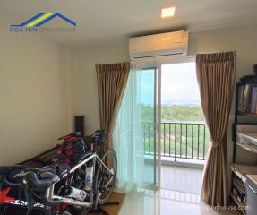 Bedroom with large window, air conditioner, and exercise bikes