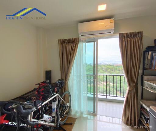 Bedroom with large window, air conditioner, and exercise bikes