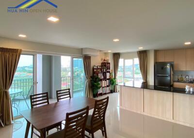 Spacious dining and kitchen area with large windows and balcony view
