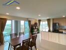 Spacious dining and kitchen area with large windows and balcony view