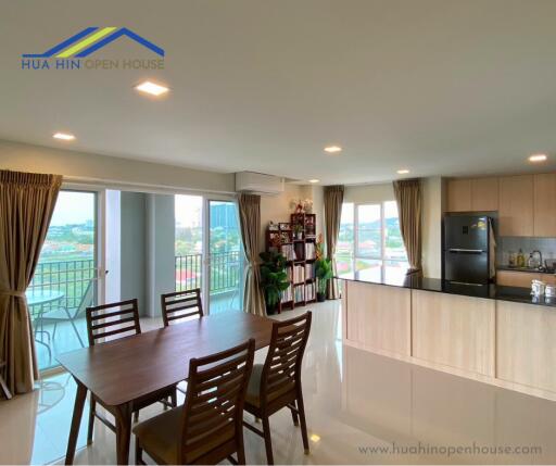 Spacious dining and kitchen area with large windows and balcony view