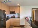 Modern kitchen with wooden cabinets, black countertop, and appliances