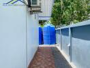 Side view of house with AC unit and water storage tanks