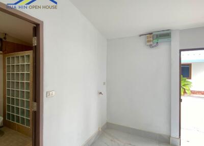 Simple hallway in a house with an adjacent bathroom and an external door