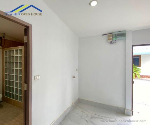 Simple hallway in a house with an adjacent bathroom and an external door