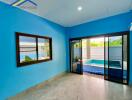 Living area with large window and glass sliding door overlooking an outdoor pool