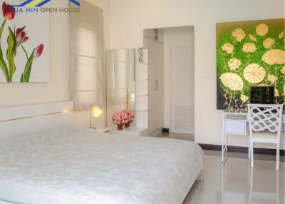 Bedroom with bed, wall art, desk, and decorative elements