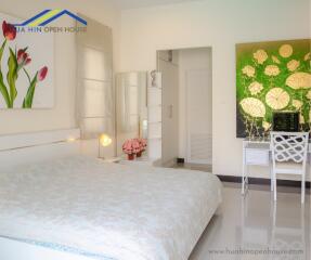 Bedroom with bed, wall art, desk, and decorative elements