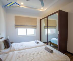 Bedroom with twin beds, mirrored wardrobe, and window