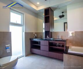 Modern bathroom with large mirror and wooden cabinets