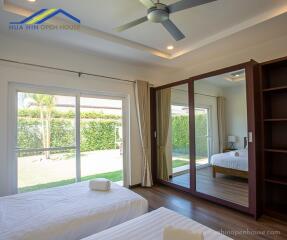 Modern bedroom with large mirrored wardrobe and garden view