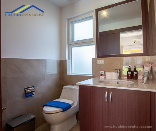 Modern bathroom with sink, toilet, mirror, and window