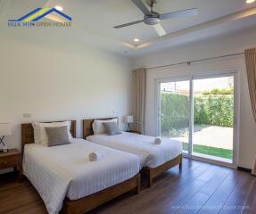 Spacious bedroom with two single beds and garden view