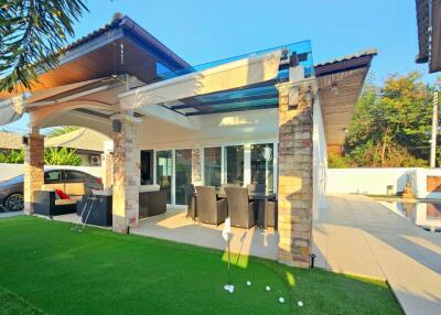 covered patio area with dining setup and golf practice spot