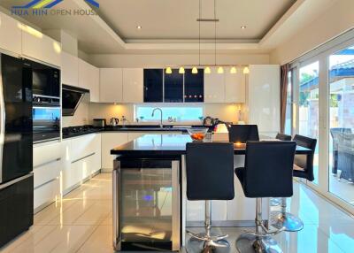 Modern kitchen with island, appliances, and bar stools