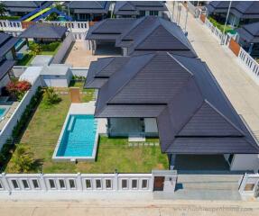 Aerial view of a modern residential property with a private pool and well-maintained backyard