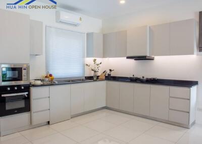 Modern kitchen with white cabinetry and built-in appliances