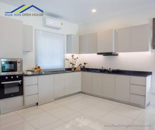 Modern kitchen with white cabinetry and built-in appliances