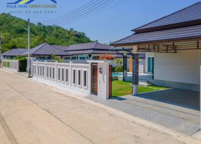 Modern residential homes with gated walls and surrounding greenery