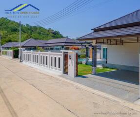 Modern residential homes with gated walls and surrounding greenery