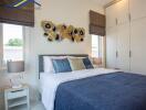 Modern bedroom with large windows, decorative wall art, and built-in storage